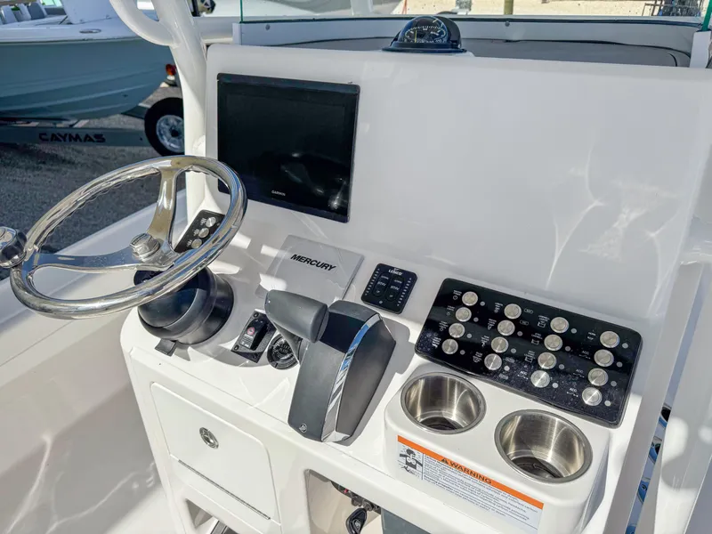 Slide: The Image of 2024 Caymas 26 HB boat dashboard with steering wheel and control panel. - 14