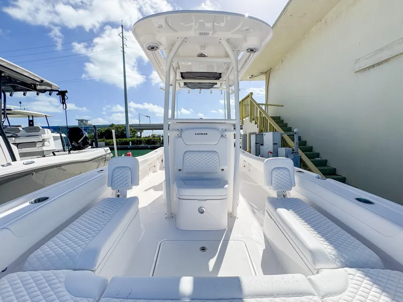 Slide: The Image of 2024 Caymas 26 HB boat interior with white seating and center console under a blue sky. - 18