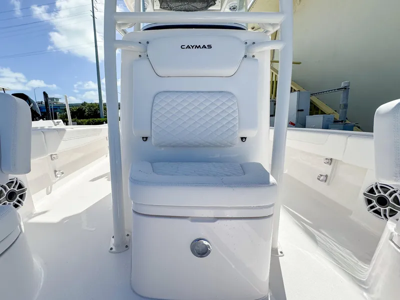 Slide: The Image of 2024 Caymas 26 HB boat interior with white cushioned seating and storage. - 19