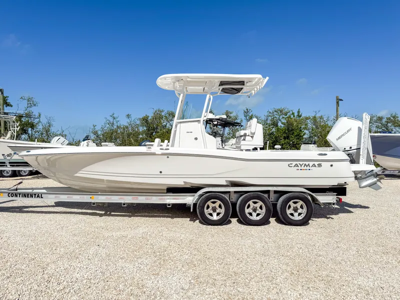 Slide: The Image of 2024 Caymas 26 HB boat on a trailer, parked outdoors under a clear blue sky. - 2