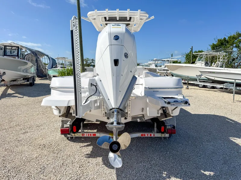 Slide: The Image of 2024 Caymas 26 HB boat rear view, showcasing engine and propeller on a trailer. - 4