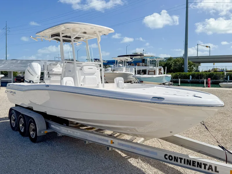 Slide: The Image of 2024 Caymas 26 HB boat on trailer under clear blue sky. - 7