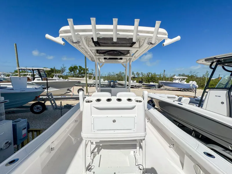 Slide: The Image of 2024 Caymas 26 HB boat with T-top and console, docked under clear blue sky. - 8