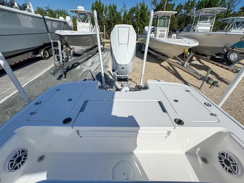 Slide: The Image of 2024 Caymas 28 HB boat with outboard motor, docked among other boats. - 10