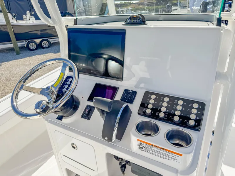 Slide: The Image of 2024 Caymas 28 HB boat dashboard with steering wheel and control panel. - 16