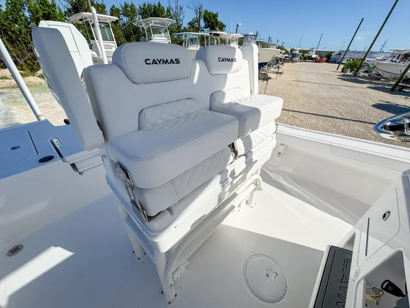 Slide: The Image of 2024 Caymas 28 HB boat with white cushioned seating in a sunny marina. - 17