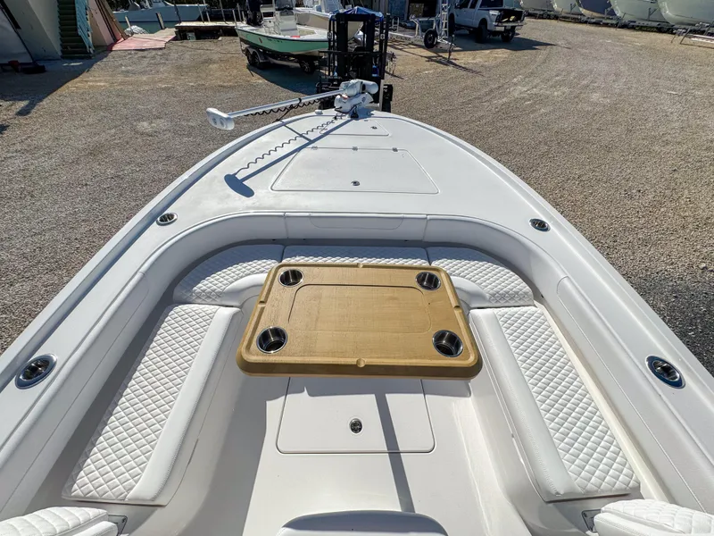 Slide: The Image of 2024 Caymas 28 HB boat deck with seating and table, parked outdoors. - 20