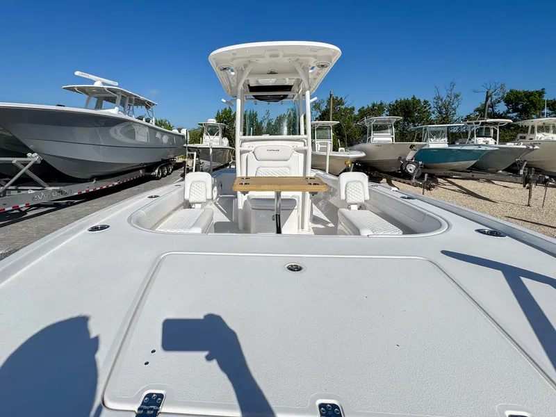 Slide: The Image of 2024 Caymas 28 HB boat with center console, docked among other boats. - 21