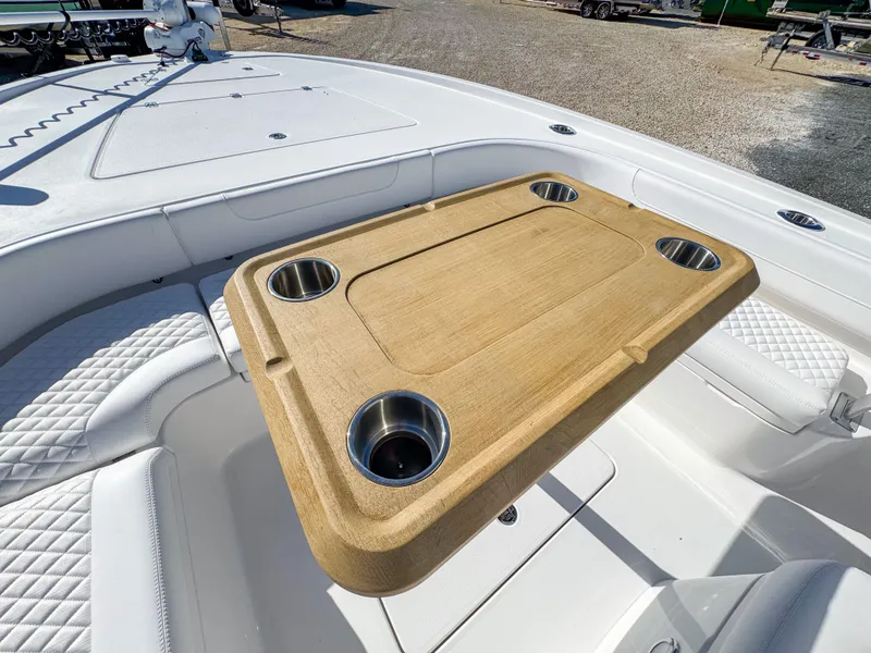 Slide: The Image of 2024 Caymas 28 HB boat with wooden table and cup holders on deck. - 22