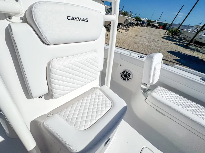 Slide: The Image of 2024 Caymas 28 HB boat interior with white quilted seating and speaker. - 23