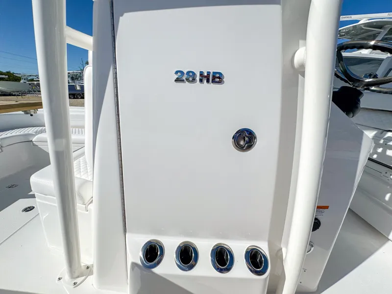 Slide: The Image of 2024 Caymas 28 HB boat console with sleek white design and chrome accents. - 28