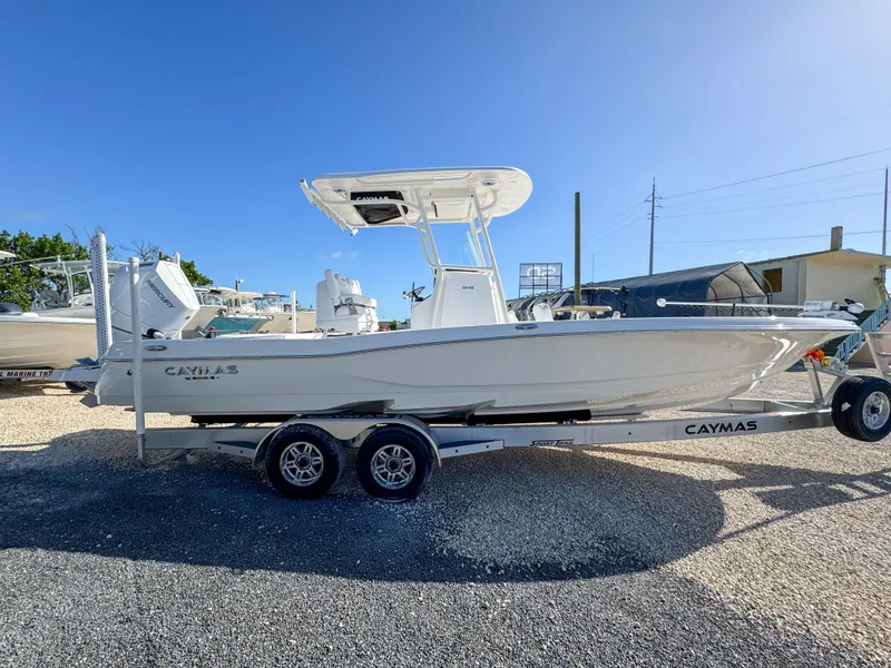 Slide: The Image of 2024 Caymas 28 HB boat on trailer, parked outdoors under clear blue sky. - 6