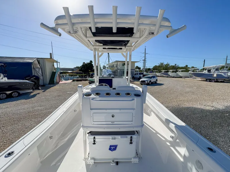 Slide: The Image of 2024 Caymas 28 HB boat with T-top and center console in a marina setting. - 8