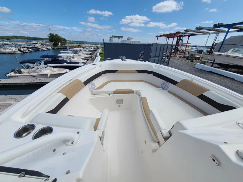 Slide: The Image of 2018 Edgewater 262 CX boat interior at marina, featuring spacious seating and clear skies. - 6