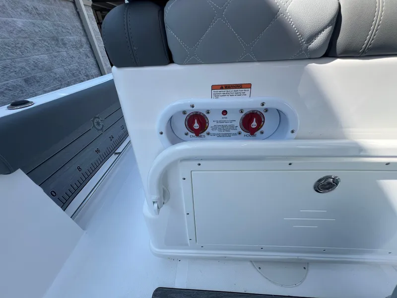 Slide: The Image of 2025 NauticStar 252L boat interior with control panel and cushioned seating. - 21