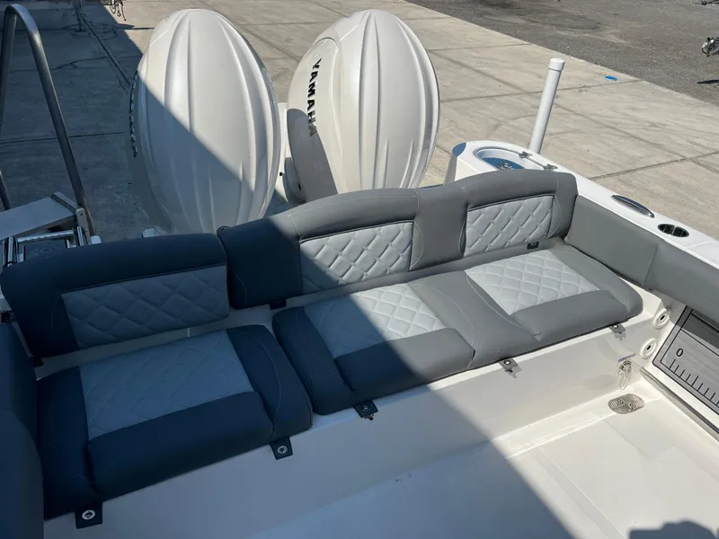 Slide: The Image of 2025 NauticStar 252L boat interior with gray cushioned seating and dual outboard engines. - 36