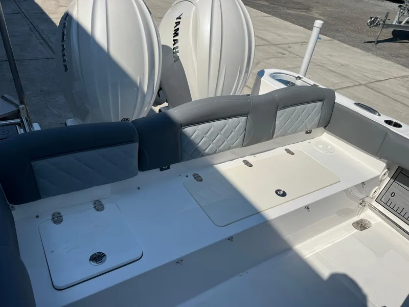 Slide: The Image of 2025 NauticStar 252L boat interior with Yamaha engines, featuring cushioned seating and storage compartments. - 38