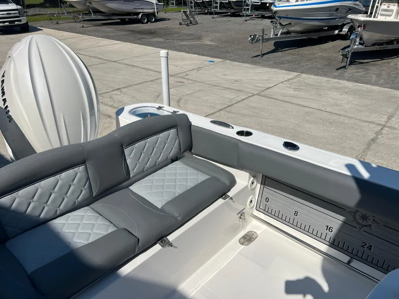 Slide: The Image of 2025 NauticStar 252L boat interior with cushioned seating and fishing rod holders. - 39