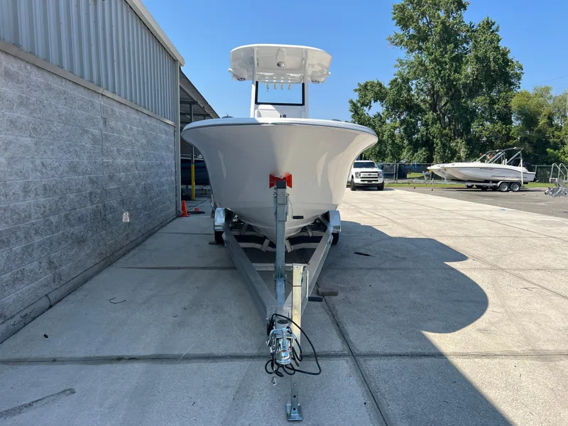 Slide: The Image of 2025 NauticStar 252L boat on trailer, parked outdoors near a building. - 1