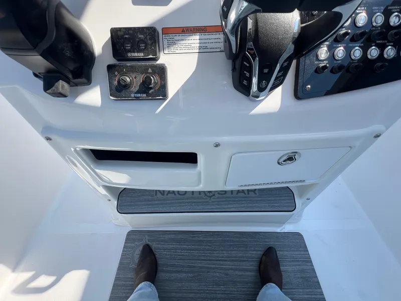 Slide: The Image of 2025 NauticStar 252L boat dashboard with controls and footrest. - 18