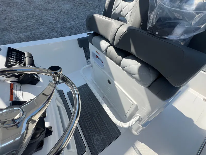 Slide: The Image of 2025 NauticStar 252L boat interior with steering wheel and cushioned seating. - 23