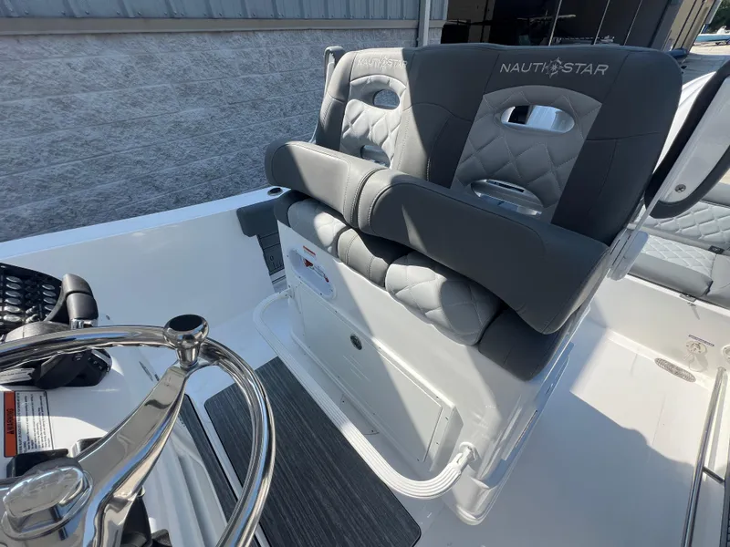 Slide: The Image of 2025 NauticStar 252L boat with plush gray seating and steering wheel. - 24
