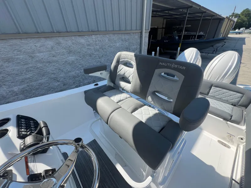 Slide: The Image of 2025 NauticStar 252L boat interior with plush seating and modern steering wheel. - 25