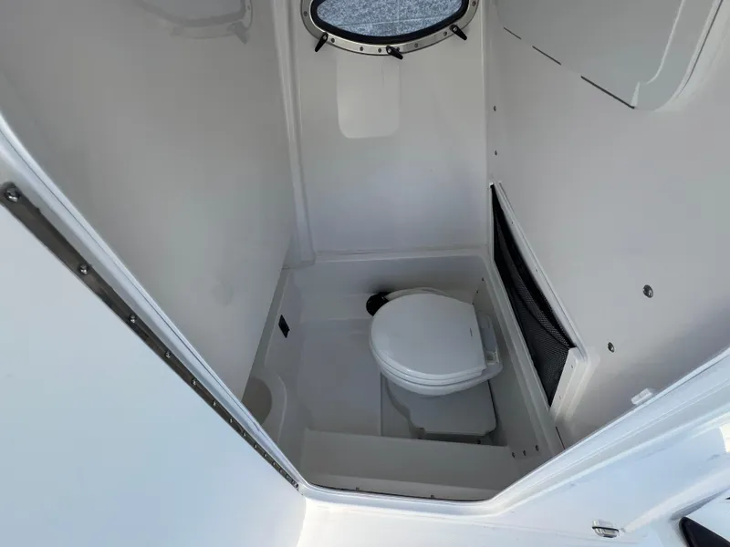 Slide: The Image of Interior of 2025 NauticStar 252L boat bathroom with compact toilet. - 26