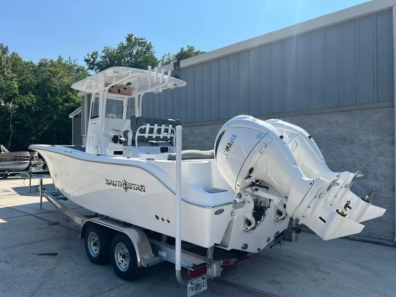 Slide: The Image of 2025 NauticStar 252L boat on trailer, dual engines, parked outdoors. - 3