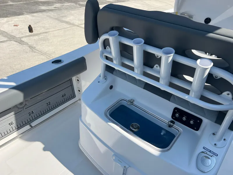 Slide: The Image of 2025 NauticStar 252L boat interior with rod holders and storage compartment. - 40