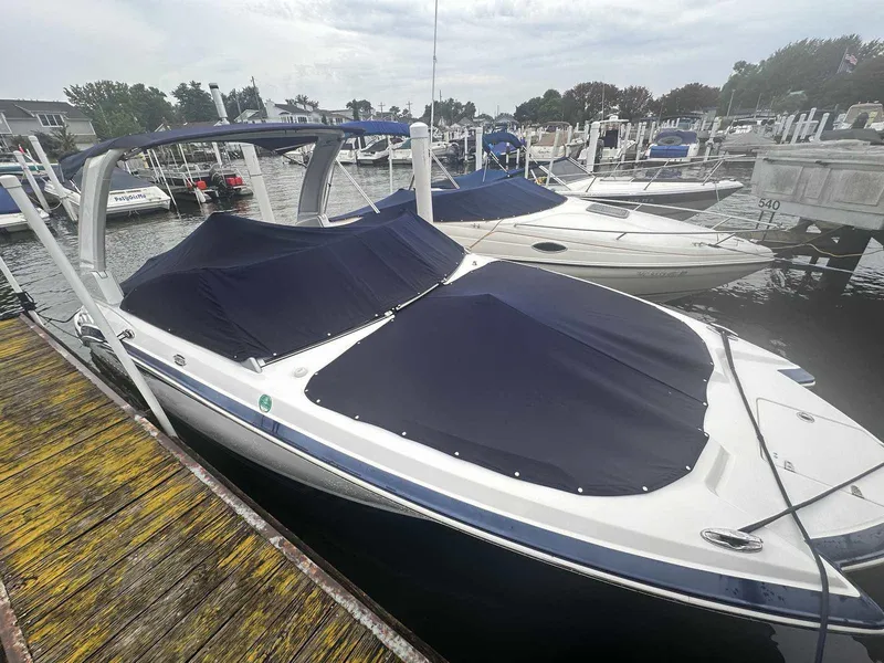 Slide: The Image of 2019 Chaparral 244 Sunesta boat docked with cover in marina. - 2
