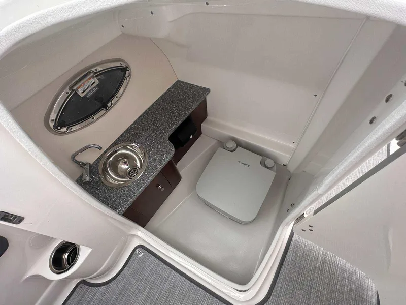 Slide: The Image of 2019 Chaparral 244 Sunesta boat interior with sink and portable toilet. - 22