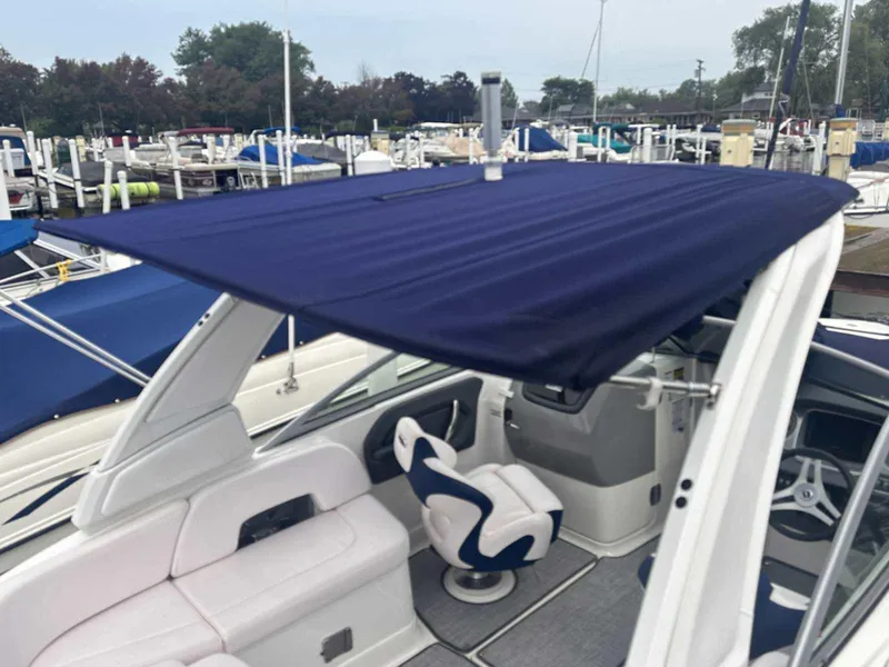 Slide: The Image of 2019 Chaparral 244 Sunesta boat with blue canopy at marina. - 35