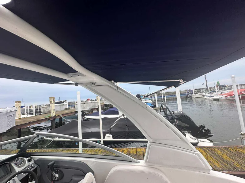 Slide: The Image of 2019 Chaparral 244 Sunesta boat docked at marina with canopy. - 36