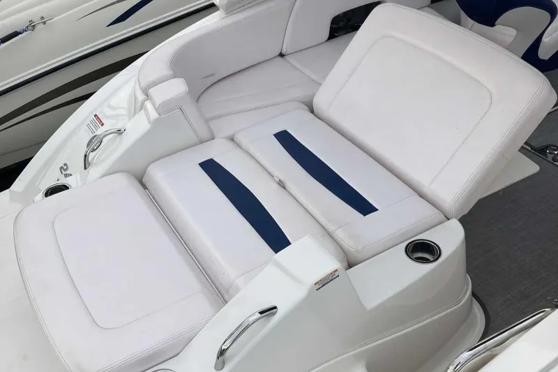 Slide: The Image of 2019 Chaparral 244 Sunesta boat with white and blue seating, cup holders, and sleek design. - 6