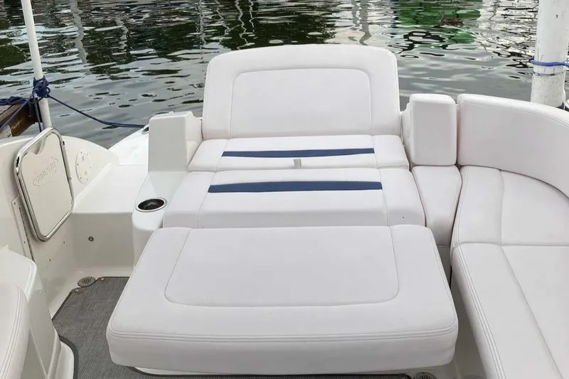 Slide: The Image of 2019 Chaparral 244 Sunesta boat interior with white seating and water view. - 7