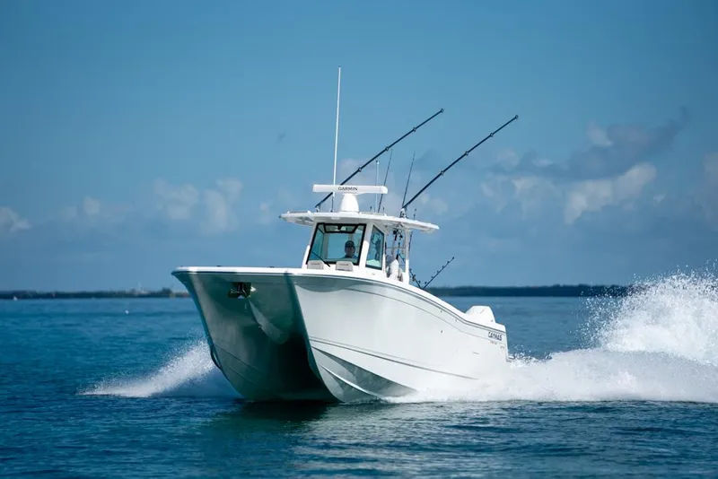 Slide: The Image of 2024 Caymas 34 CT boat cruising on open water, clear blue sky. - 0