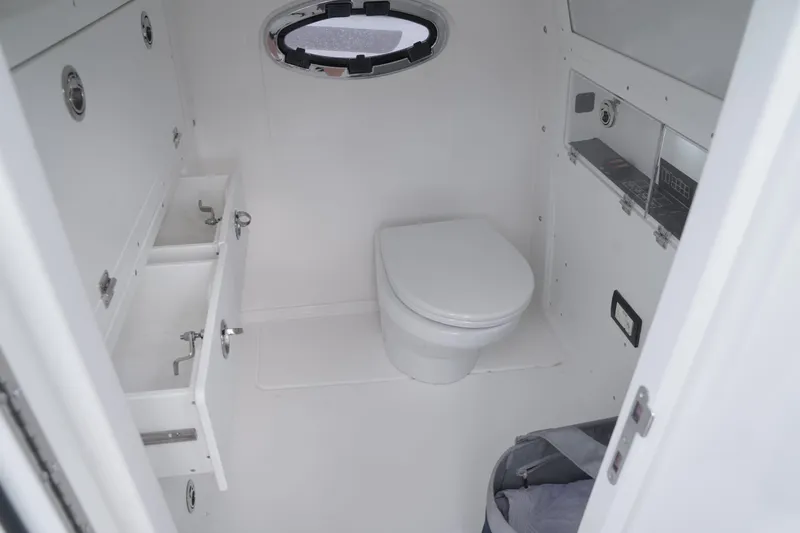 Slide: The Image of 2024 Caymas 34 CT boat bathroom with toilet, sink, and porthole window. - 21