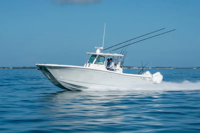 Slide: The Image of 2024 Caymas 34 CT boat cruising on open water, clear blue sky. - 4