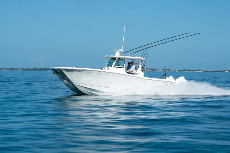 Slide: The Image of 2024 Caymas 34 CT boat cruising on open water under clear blue skies. - 8