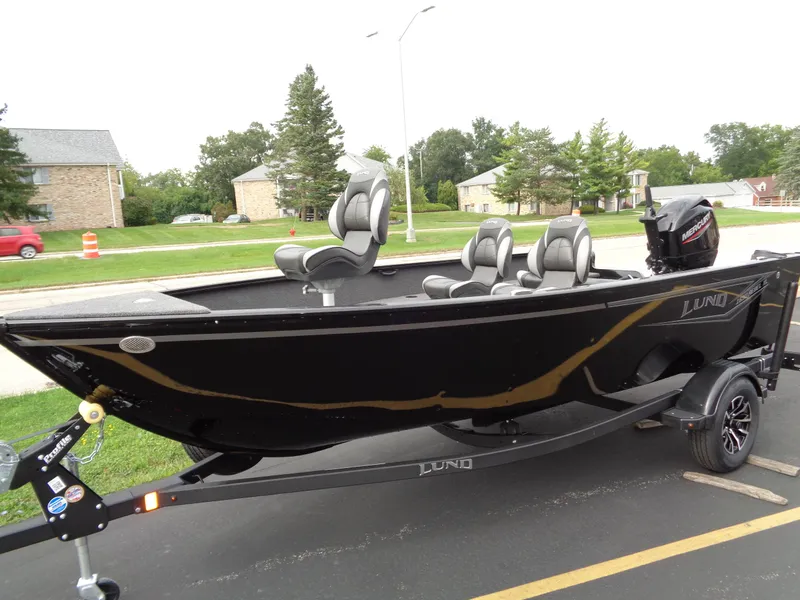 Slide: The Image of 2025 Lund 1650 Rebel XL Tiller boat on trailer, parked outdoors. - 13