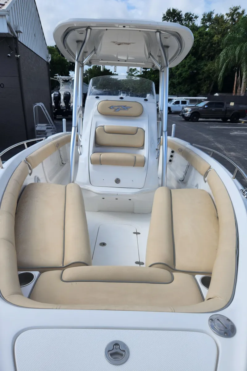 Slide: The Image of 2018 Glasstream 255 Pro-XS boat with beige seating and T-top in a marina setting. - 9