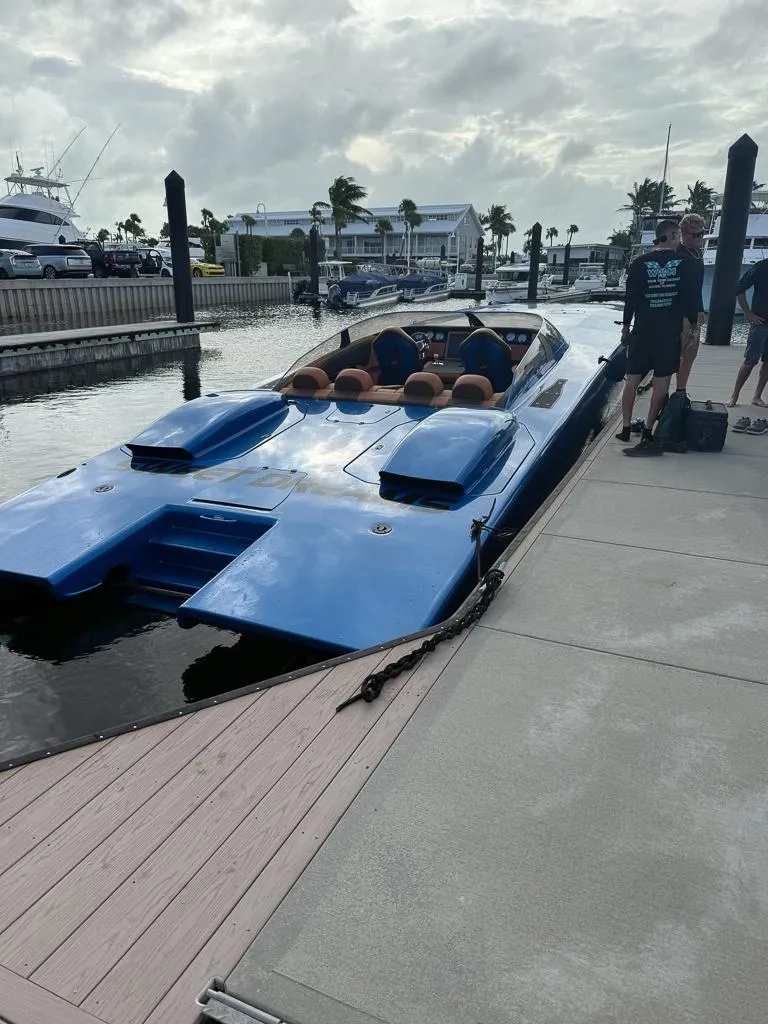 Slide: The Image of Blue Skater 46 speedboat docked at marina, cloudy sky, people nearby, 2013 model. - 3