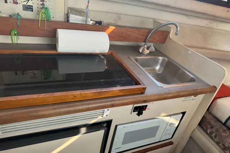 Slide: The Image of 1996 Bayliner 2452 Ciera Express Hardtop galley with stove, sink, and microwave. - 16