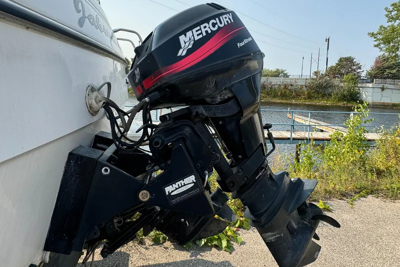 Slide: The Image of Outboard motor on 1996 Bayliner 2452 Ciera Express Hardtop by the water. - 22