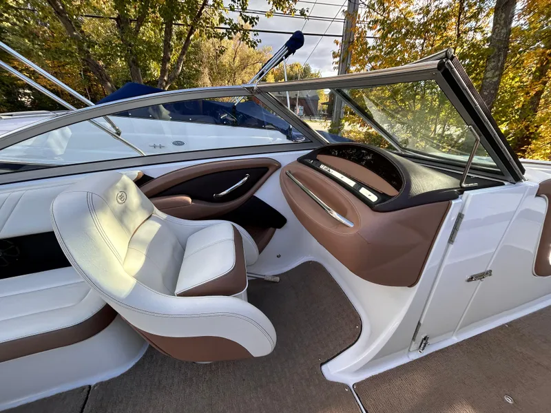 Slide: The Image of 2012 Cobalt 232 Bowrider interior with white and brown seating, sleek dashboard, and open cockpit. - 25