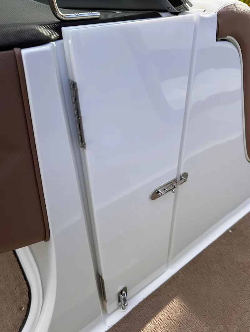 Slide: The Image of 2012 Cobalt 232 Bowrider interior door with brown trim and latch. - 32