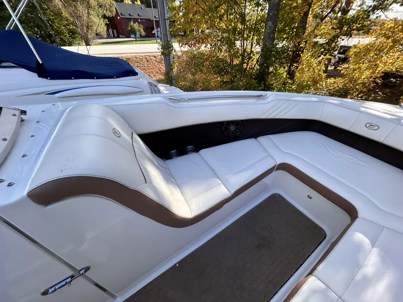 Slide: The Image of 2012 Cobalt 232 Bowrider interior with white and brown seating, outdoor setting. - 35