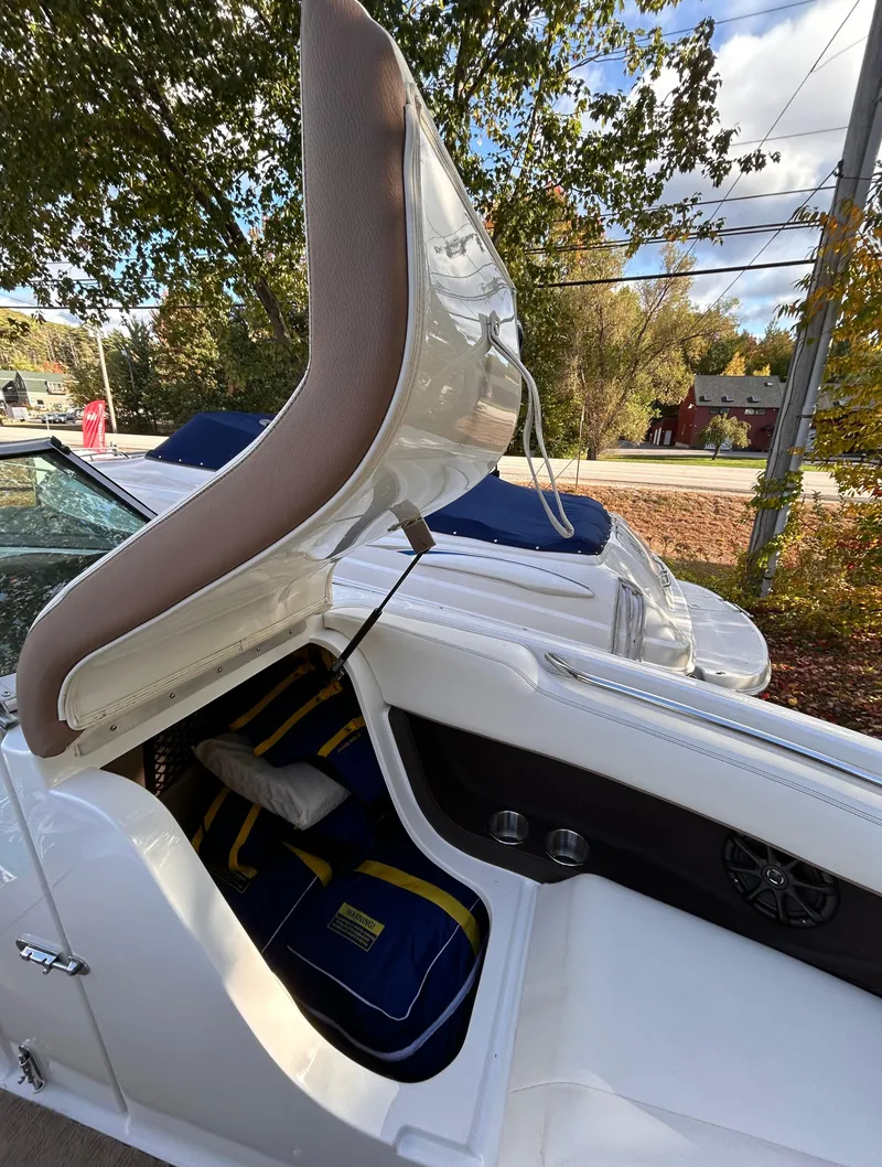 Slide: The Image of 2012 Cobalt 232 Bowrider boat with open storage compartment, outdoor setting. - 36