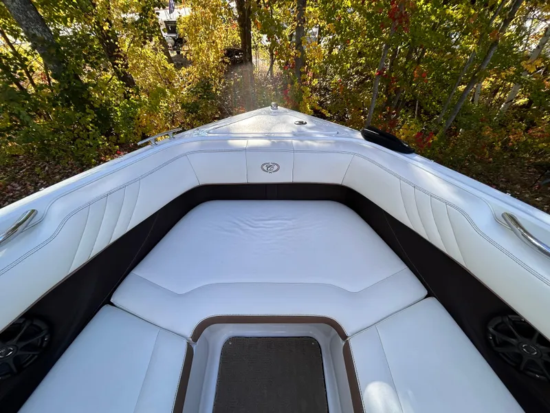 Slide: The Image of 2012 Cobalt 232 Bowrider boat interior with white seating and wooded background. - 37